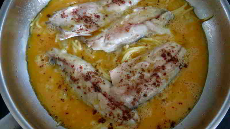 Noch halbgare Makrelenfilets auf Bratnudeln mit Rührei und rosa Pfeffer